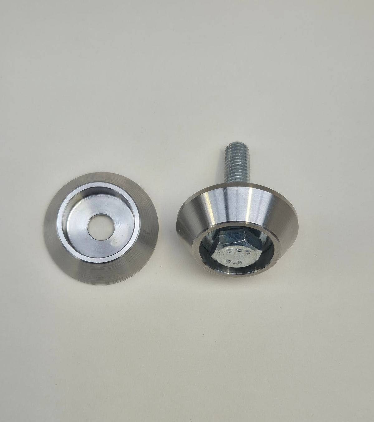 Bolt head protector shown empty beside a second protector fitted around a hex-head bolt