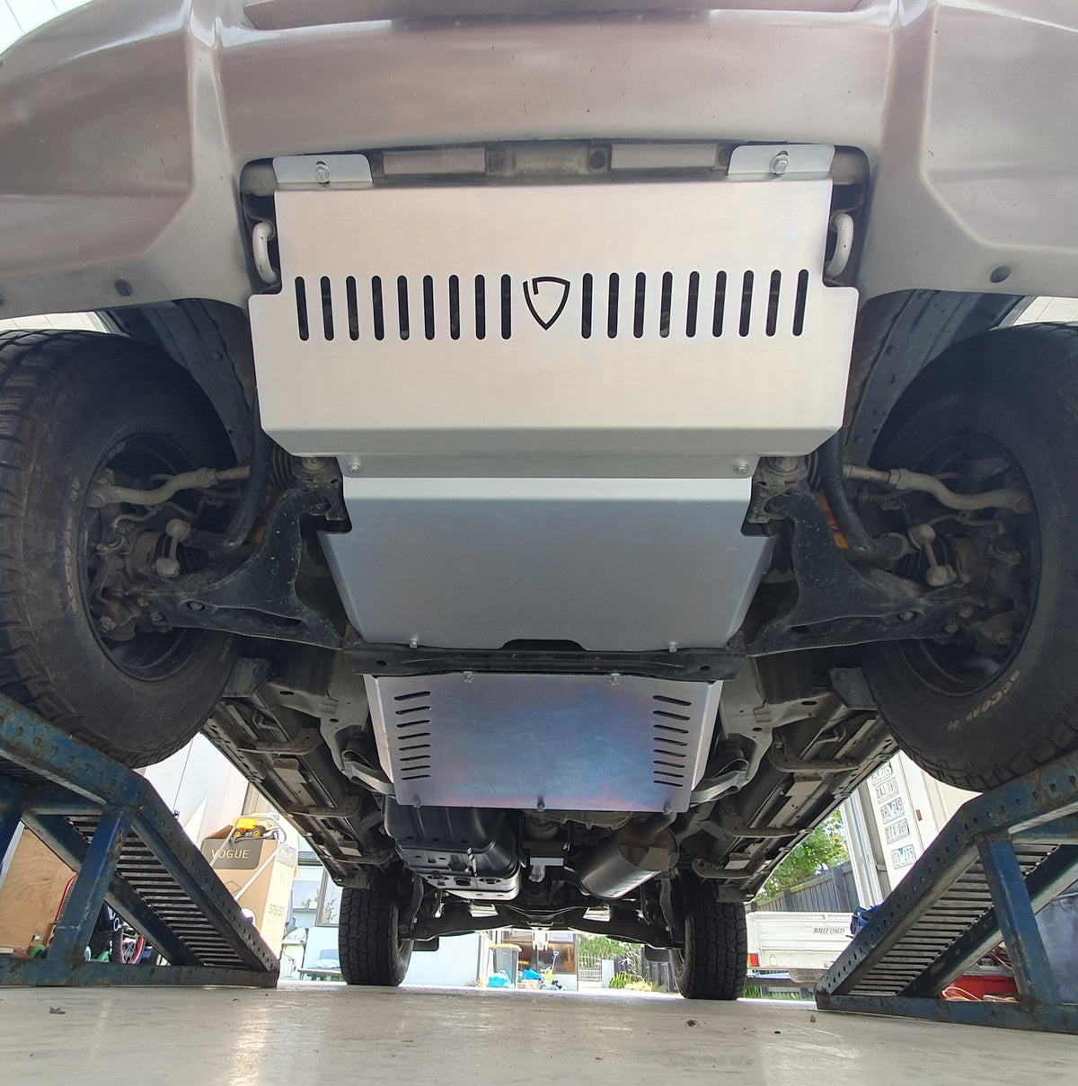 Full underside view of Mitsubishi Pajero Gen 3 bash plates showing vented front panel and slotted rear guard