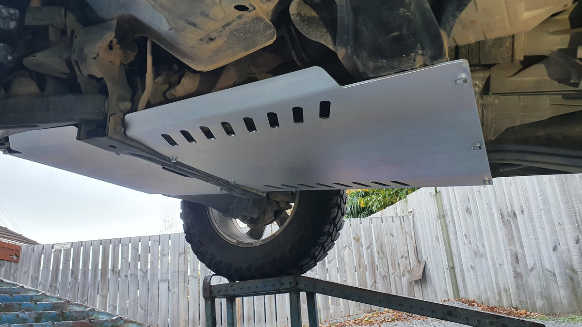 Side underside view of Pajero Gen 3 rear bash plate showing diagonal slots and folded edges