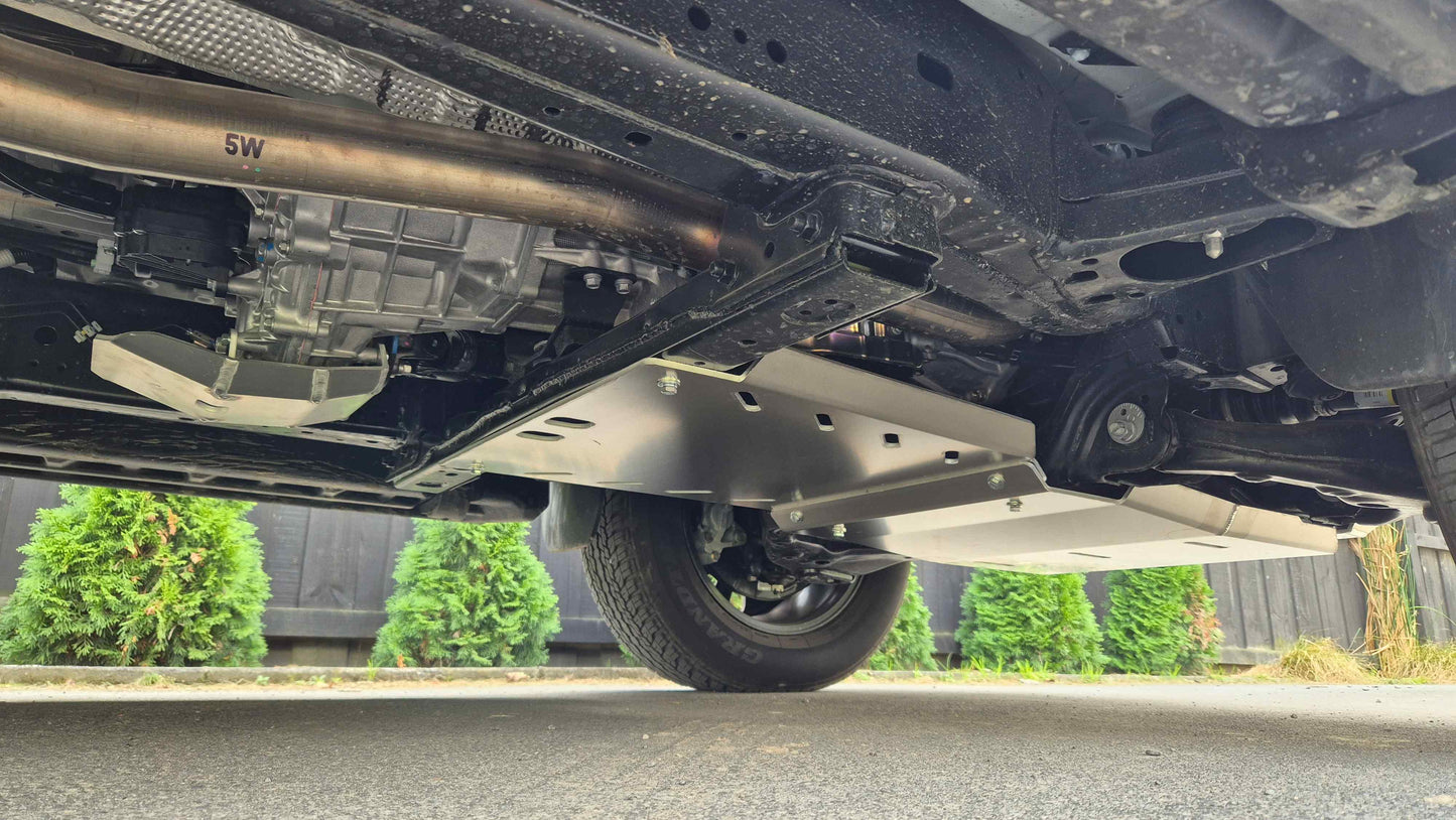 Close-up of a vehicle's undercarriage with a visible suspension system. Toyota Hilux N90 Bash Plates