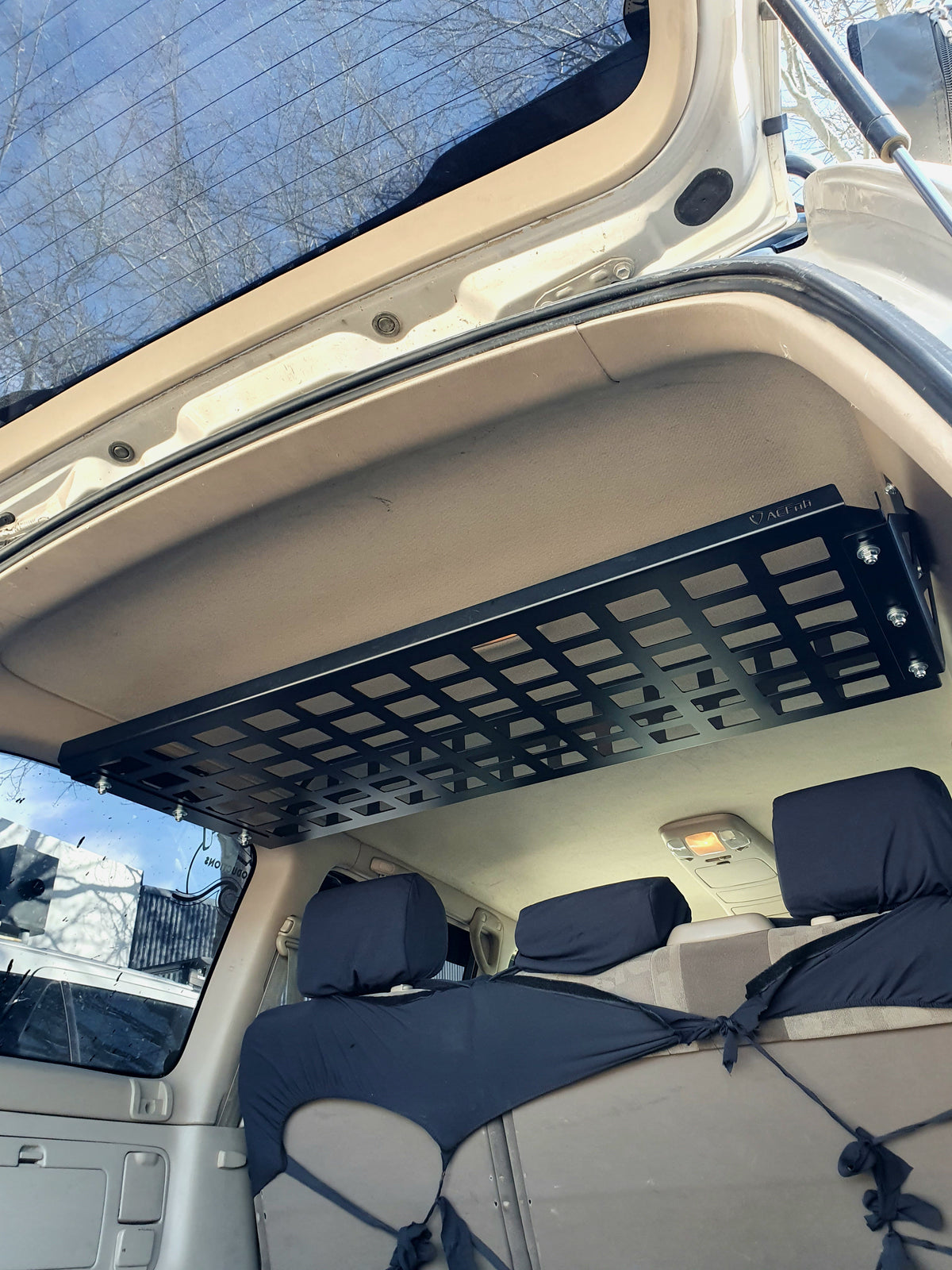 Low rear view of Landcruiser 100 cargo shelf showing storage space below the roof