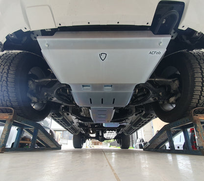 Underbody view of a vehicle with a set of metal bash plates installed, predominantly silver in color.