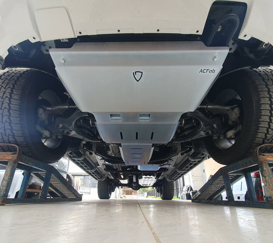 Underbody view of a vehicle with a set of metal bash plates installed, predominantly silver in color.