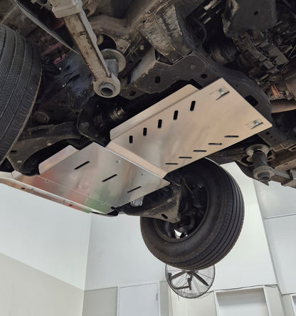 Undercarriage of a vehicle with a protective metal skid plate on a white background
