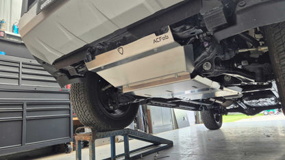 Undercarriage of a vehicle with a flatbed trailer attached, showing 'ACFab' branding.